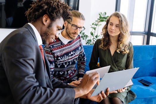 A diverse group of young professionals engaged in a business meeting inside a modern office.