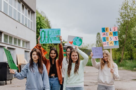 Group of young women holding signs during an outdoor environmental protest.